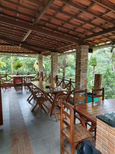 un grupo de mesas y sillas de madera en un patio en CASINHA DA SERRA, en Baturité