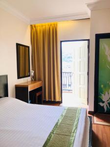 a bedroom with a bed and a desk and a window at Hotel Chua Gin in Cameron Highlands