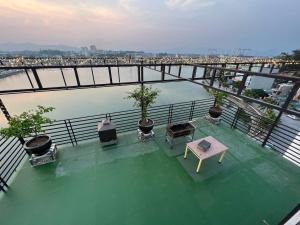 Un balcón con mesa, sillas y una masa de agua. en Kim Dung Ha Long, en Ha Long