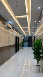 un couloir vide avec une usine de pot dans un bâtiment dans l'établissement فندق ايوان, à Qal'at Bishah