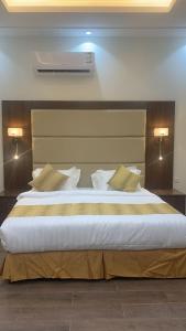 un grande letto in una camera da letto con due luci accese di فندق ايوان a Qal'at Bishah