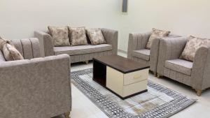 a living room with three couches and a coffee table at فندق ايوان in Qal'at Bishah