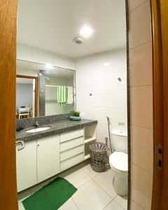 a bathroom with a sink and a toilet and a mirror at Flat no Carneiros Beach Resort in Tamandaré