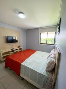 a bedroom with a bed and a flat screen tv at Flat no Carneiros Beach Resort in Tamandaré