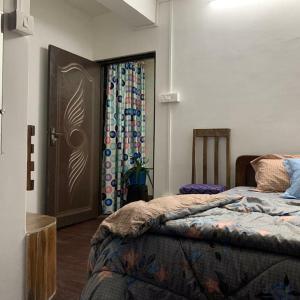 a bedroom with a bed and a door with curtains at GIRIN Homestay in Darjeeling
