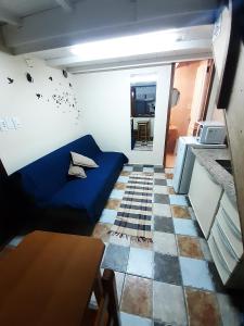 a small living room with a blue couch and a table at Pousada Reino Encantado - São Thomé das Letras - Minas Gerais in São Thomé das Letras