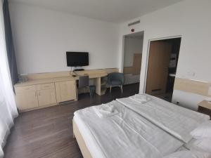 ブダペストにあるCorner Hotel Angyalföldのベッドルーム(ベッド1台、デスク、テレビ付)