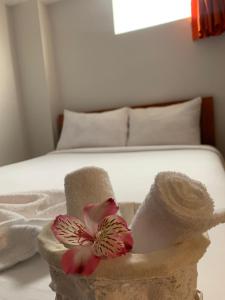 クスコにあるAlegrias Inn Hotelのベッド(タオル付)、バスケット(花付)