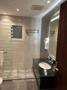 ein Bad mit einem Waschbecken und einer Dusche in der Unterkunft Moments Hotel in Dschidda