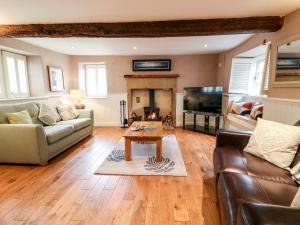 a living room with a couch and a table and a fireplace at Christmas Cottage in Alfreton