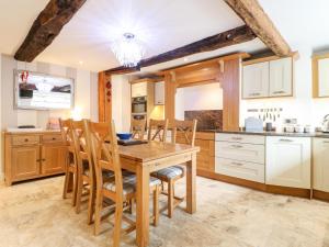 a kitchen with a wooden table and chairs at Christmas Cottage in Alfreton