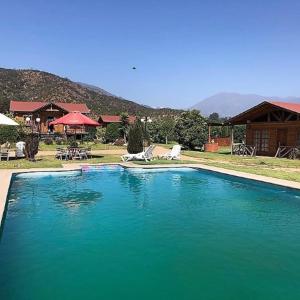 een groot zwembad met blauw water voor een huis bij Gran Parcela Monte de Olmue in Olmué