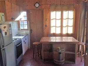 a kitchen with a counter and a refrigerator and a stove at Gran Parcela Monte de Olmue in Olmué +10 photos