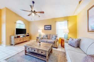 uma sala de estar com um sofá e uma televisão em Palm Cove Seaside Sunrise em Panama City Beach