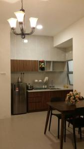 a kitchen with a table and a stainless steel refrigerator at Golden Hill 3 Room Apt @ Night Market in Cameron Highlands