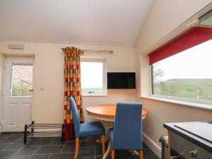 uma cozinha com mesa e cadeiras e uma janela em The Piggery em Macclesfield
