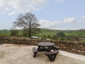 un tavolo da picnic accanto a un muro di pietra di The Piggery a Macclesfield