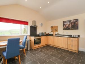 una cucina con tavolo, sedie, tavolo e finestra di The Piggery a Macclesfield