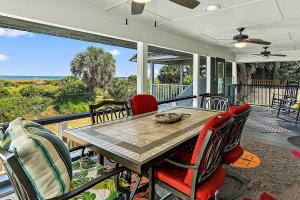 a screened in porch with a wooden table and chairs at Gypsy Belle in Saint Augustine