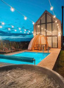 una piscina di lusso con un edificio a cupola con una tenda di DREAM HOUSE PALANGA WITH PRIVATE SWIMMING POOL, Hot Tub and Sauna a Palanga
