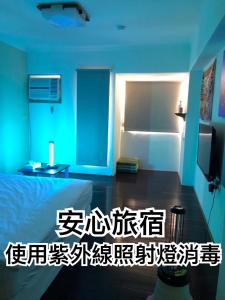 Dieses blaue Zimmer verfügt über ein Bett und einen Kühlschrank. in der Unterkunft 逢甲 Toy RooM in Taichung