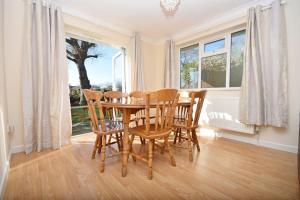 uma sala de jantar com uma mesa e cadeiras e uma janela em St Marys, Hayling Island em South Hayling