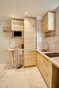una cocina con armarios de madera y fregadero en LES PERLES AMIÉNOISES ☆ WHITE PEARL ☆ HYPER CENTRE ☆, en Amiens