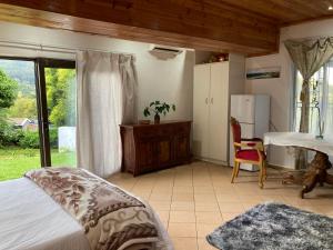 a bedroom with a bed and a table and a refrigerator at Su Casa Chase Valley VA in Pietermaritzburg