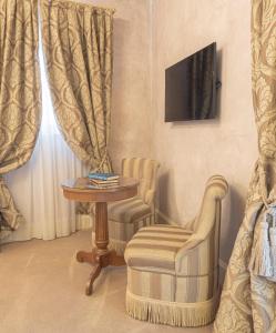 a living room with a chair and a table and a television at Hotel Villa Barbarich Venice Mestre in Mestre