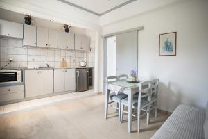 a kitchen with a table and chairs in a room at Elleana south Corfu in Agios Georgios
