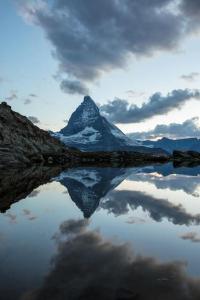 a mountain with its reflection in a body of water at Chalet Rofel in Zermatt