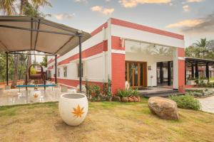 ein Haus mit einer großen Vase davor in der Unterkunft The Croft Resort - Premium Farm Stay in Thoothukudi