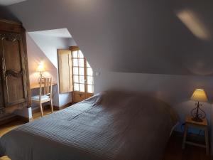 ein Schlafzimmer mit einem großen Bett und einem Fenster in der Unterkunft Gite du Bois de la Salle in Pléguien