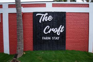 un cartello sul lato di un edificio di mattoni di The Croft Resort - Premium Farm Stay a Tuticorin