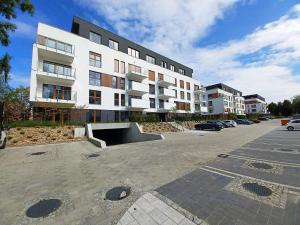 a large white building with a skate park in a parking lot at Kima Apartament Bażantów 40 in Katowice