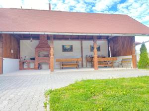 einen Pavillon mit zwei Bänken und einem gemauerten Kamin in der Unterkunft Absolut Residence Hateg in Haţeg