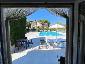 uma vista para um pátio com uma mesa e cadeiras e uma piscina em Appartamenti Alice em Lazise