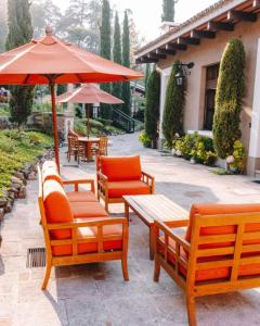 a group of chairs and tables and an umbrella at Villa Detalles in Antigua Guatemala
