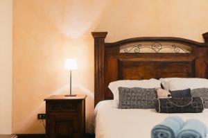a bedroom with a wooden bed with pillows and a lamp at Villa Detalles in Antigua Guatemala