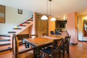 a dining room with a table and chairs and a staircase at Villa Detalles in Antigua Guatemala