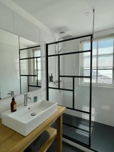 
a bathroom with a sink, mirror, and bathtub at Brise du Large - Maison d'Ault in Ault
