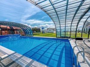 a large swimming pool with a glass roof at Twój Port in Krynica Morska