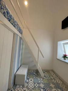a staircase in a room with a tiled floor at Petit Maison Jeranto in Nerano