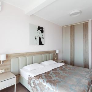 a bedroom with a large white bed and a nightstand at Altezza Premium Tophill best view and pool in Budva