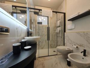 Porta Romana Gold Suite في ميلانو: حمام مع حوض ومرحاض ودش