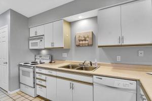 布蘭森的住宿－Fairway Heights condo，厨房配有白色橱柜和水槽