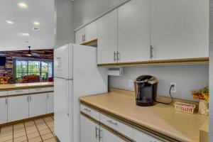 a kitchen with white cabinets and a refrigerator at Fairway Heights condo in Branson