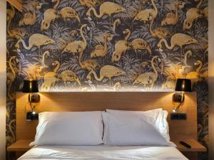 Porta Romana Gold Suite في ميلانو: غرفة نوم بسرير وورق جدران مع فلامنغو