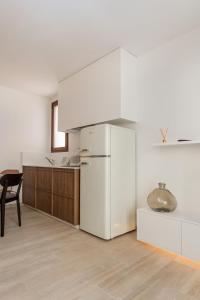 a white kitchen with a refrigerator and a table at Pizarro by Seaward Suites in Villajoyosa