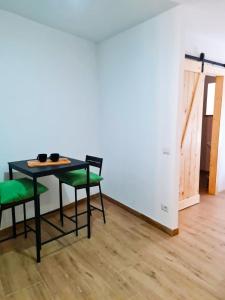 Apartment 1913 في Ponticelli: طاولة سوداء مع كراسي خضراء في الغرفة